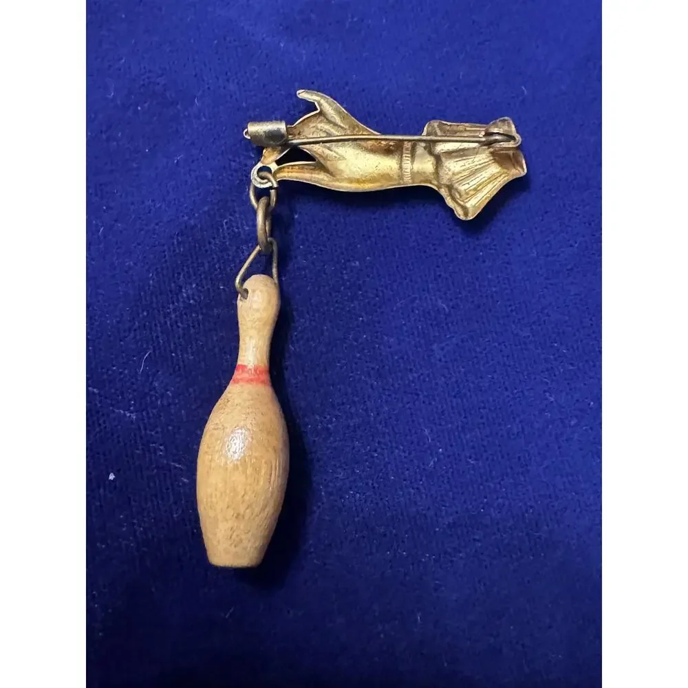 Vintage 50's brass hand with dangling miniature bowling pin brooch